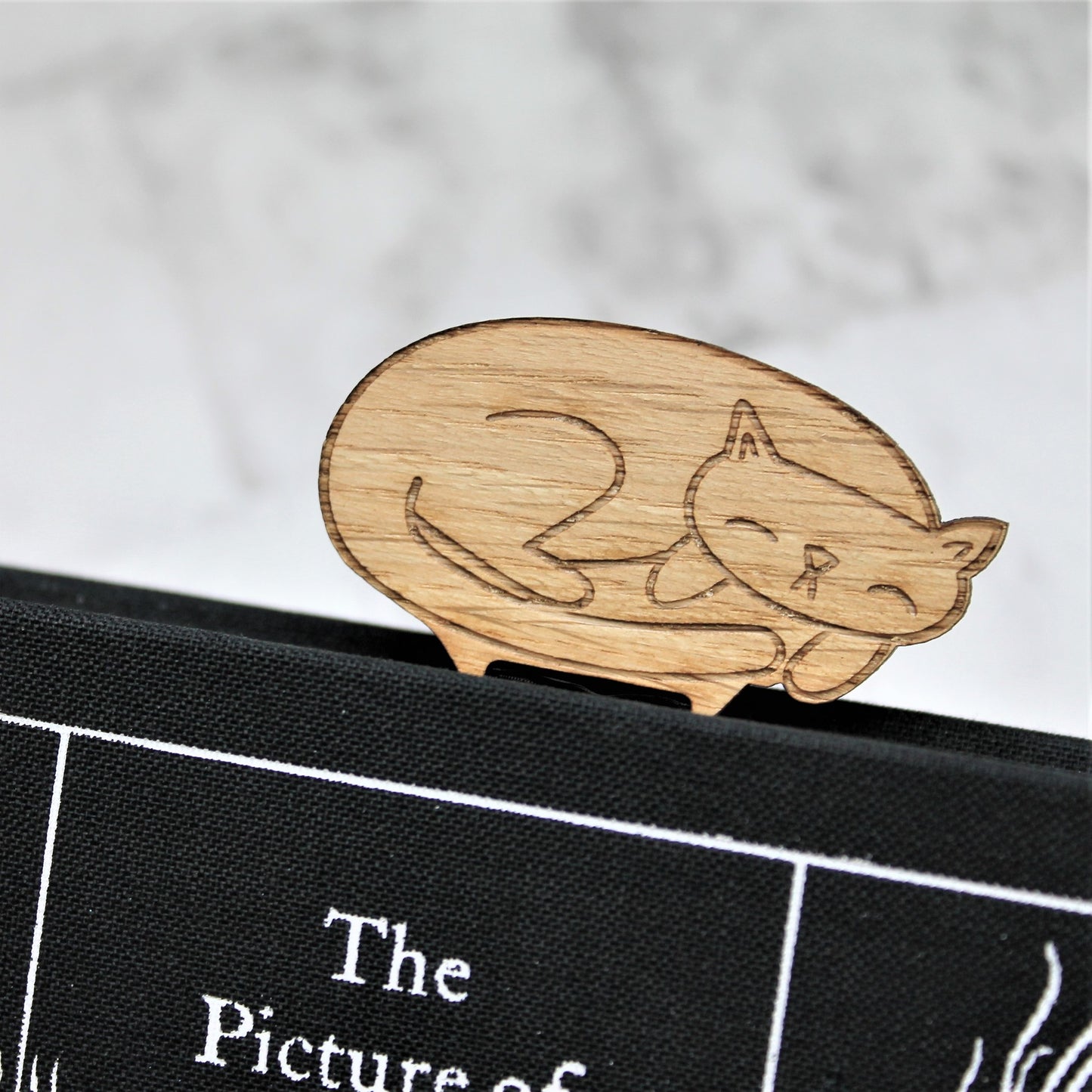 Sleepy cat bookmark made from wood and ribbon, to keep your place in a book