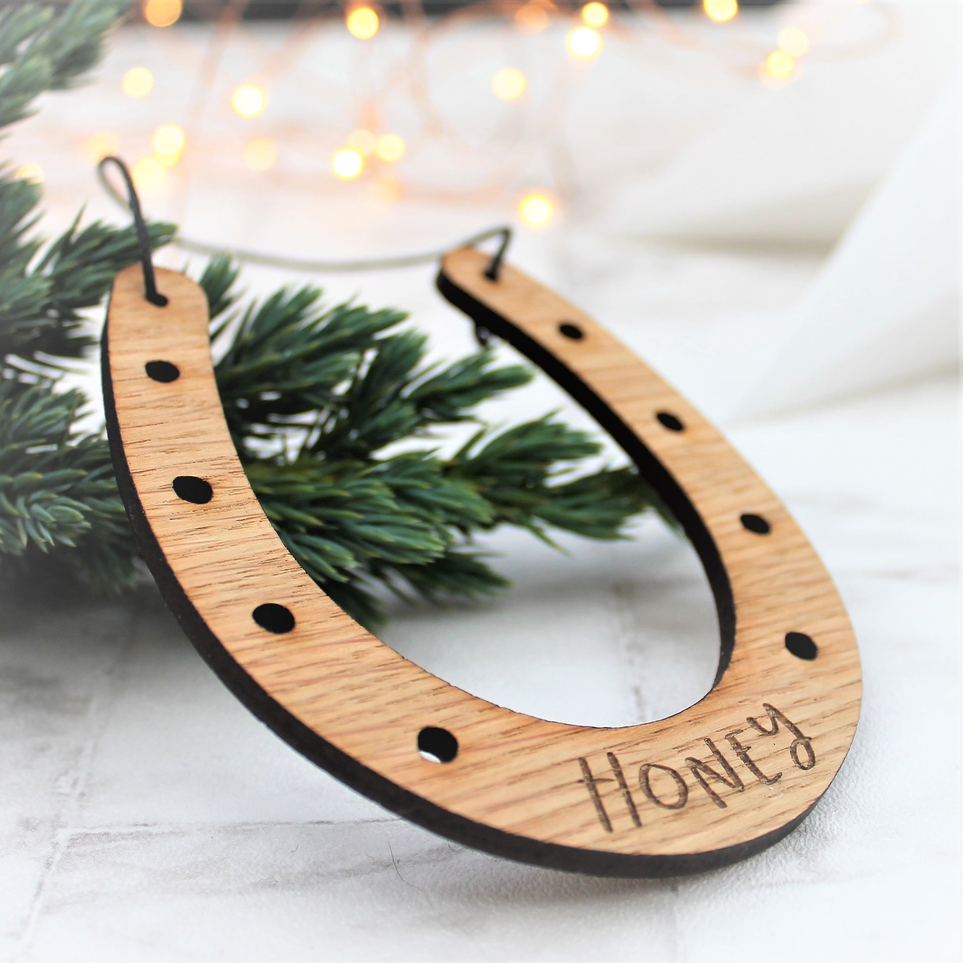 Wooden engraved horseshoe Christmas tree decoration with personalised name etched onto it.