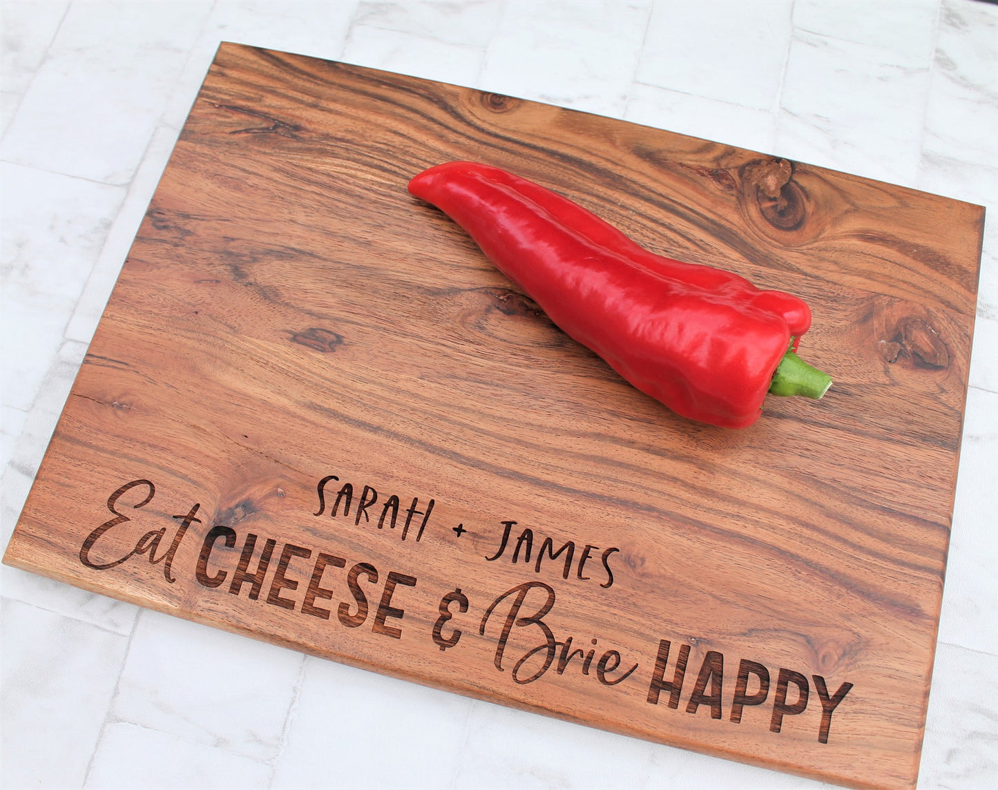 Personalised wooden cheese serving board engraved with custom names and funny brie quote: eat cheese and brie happy