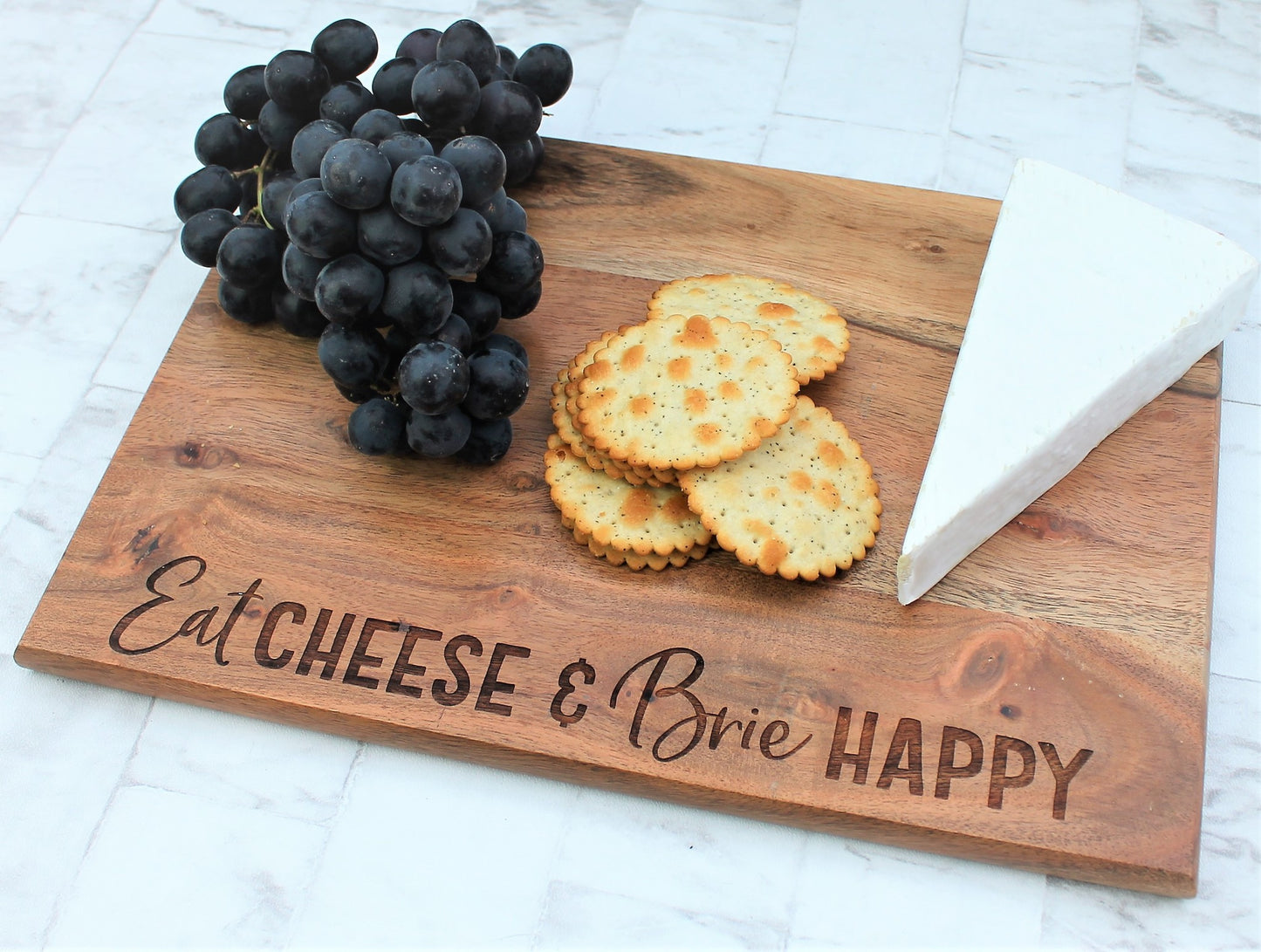 Wooden engraved chopping board with the words eat cheese and brie happy