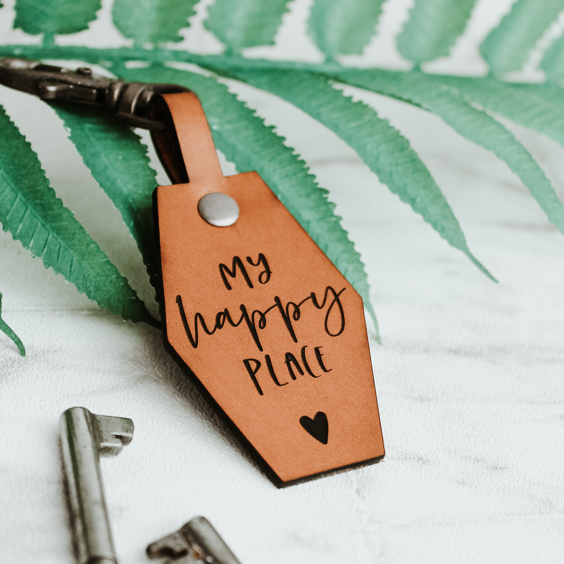 my happy place engraved onto a whisky coloured leather keyring with a heart motif.  