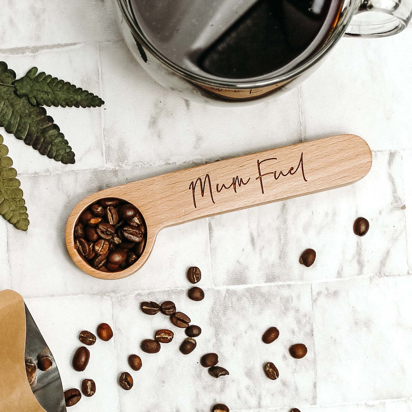 wooden coffee spoon and clip engraved with the words mum fuel filled with coffee beans