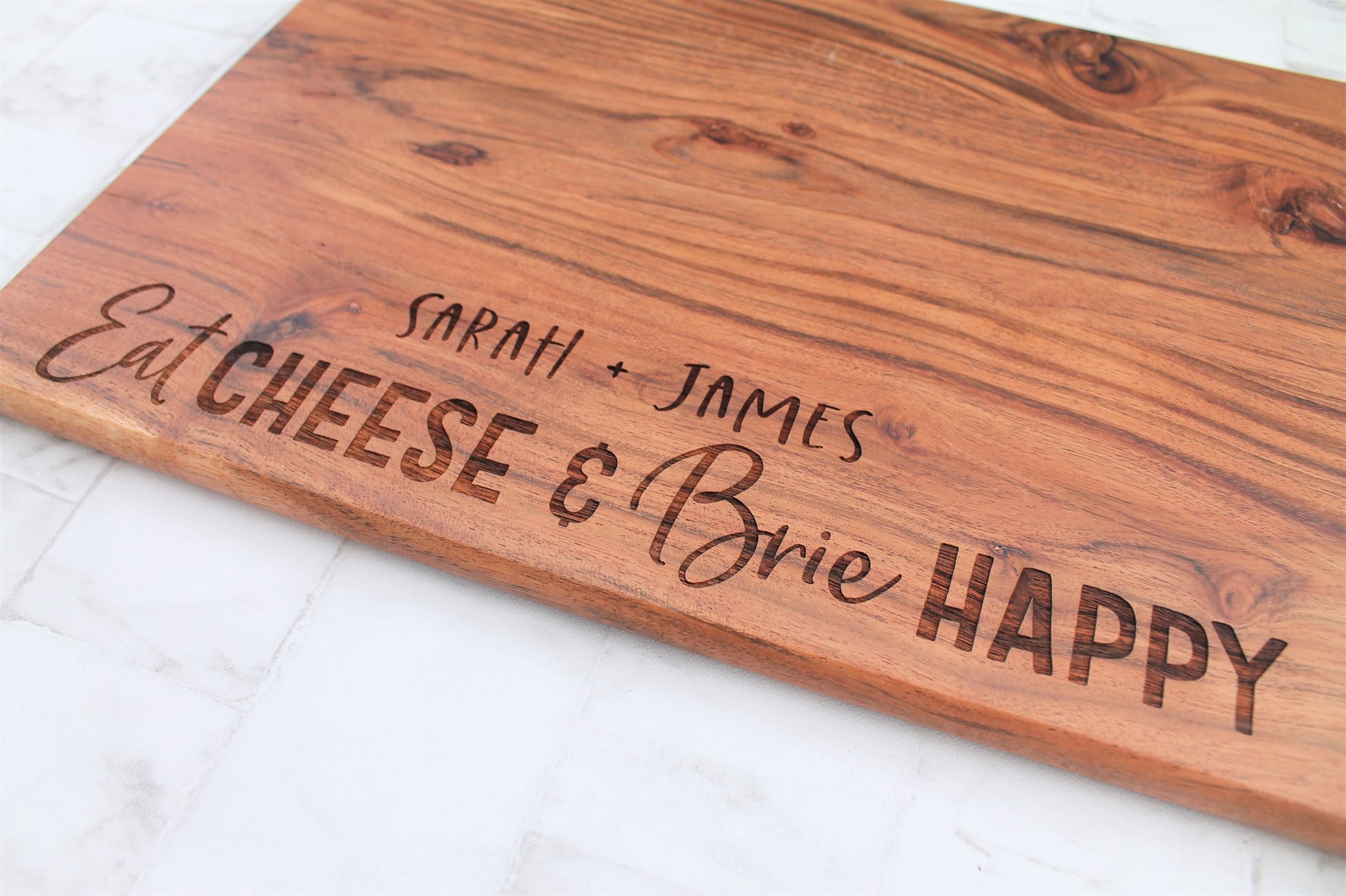 Personalised chopping board for cheese lovers. Engraved with the words eat cheese and brie happy