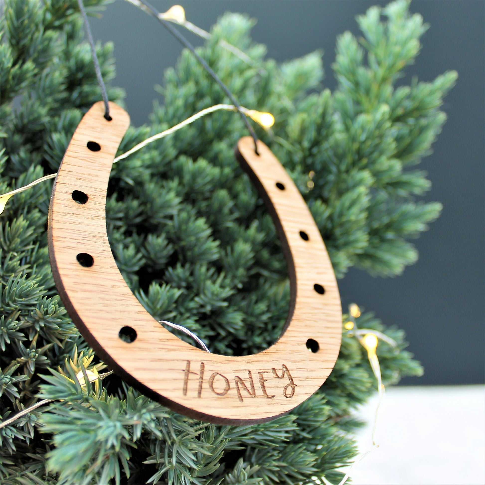 Wooden engraved horseshoe Christmas tree decoration with personalised name etched onto it.