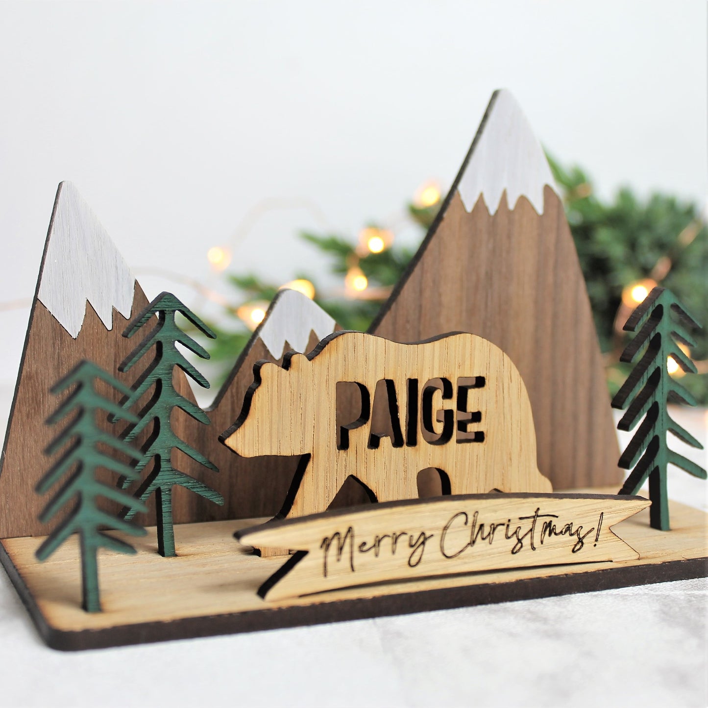 3d festive wooden ornament with mountain and forest scene, and a personalised name bear