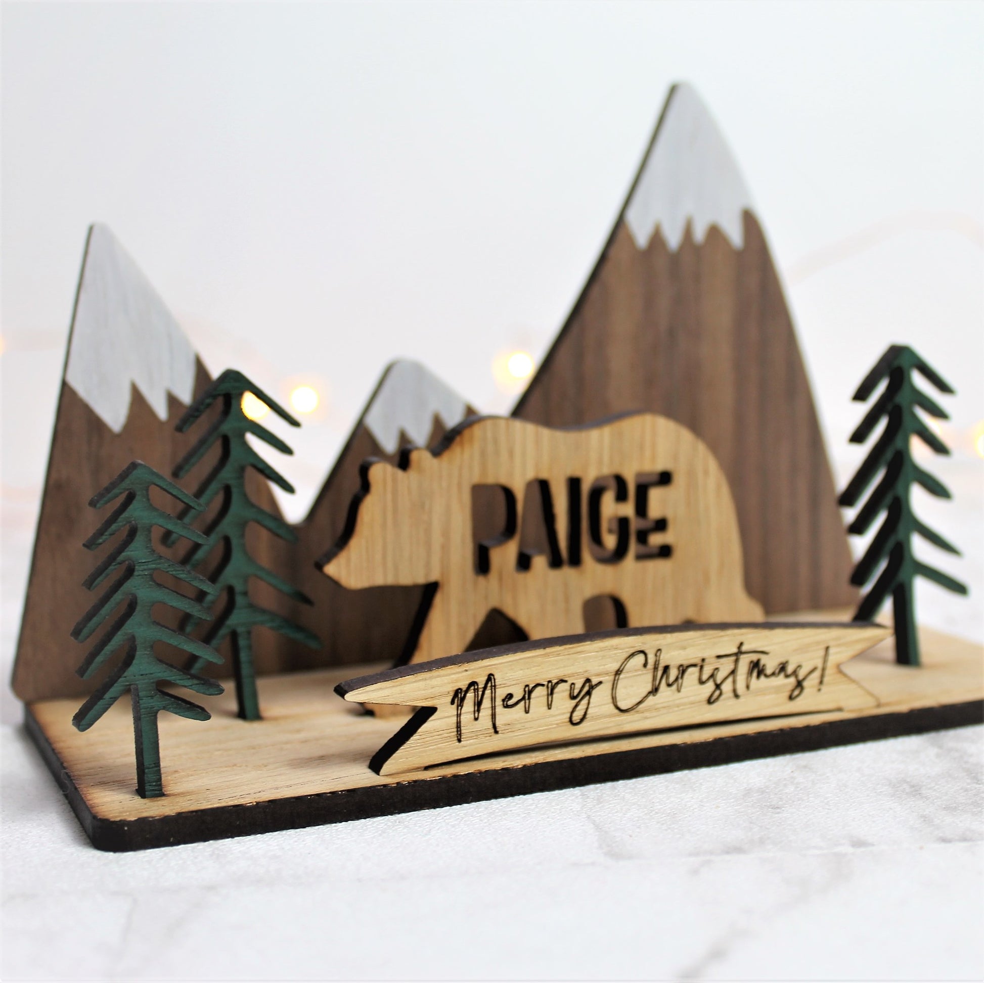 3d festive wooden ornament with mountain and forest scene, and a personalised name bear
