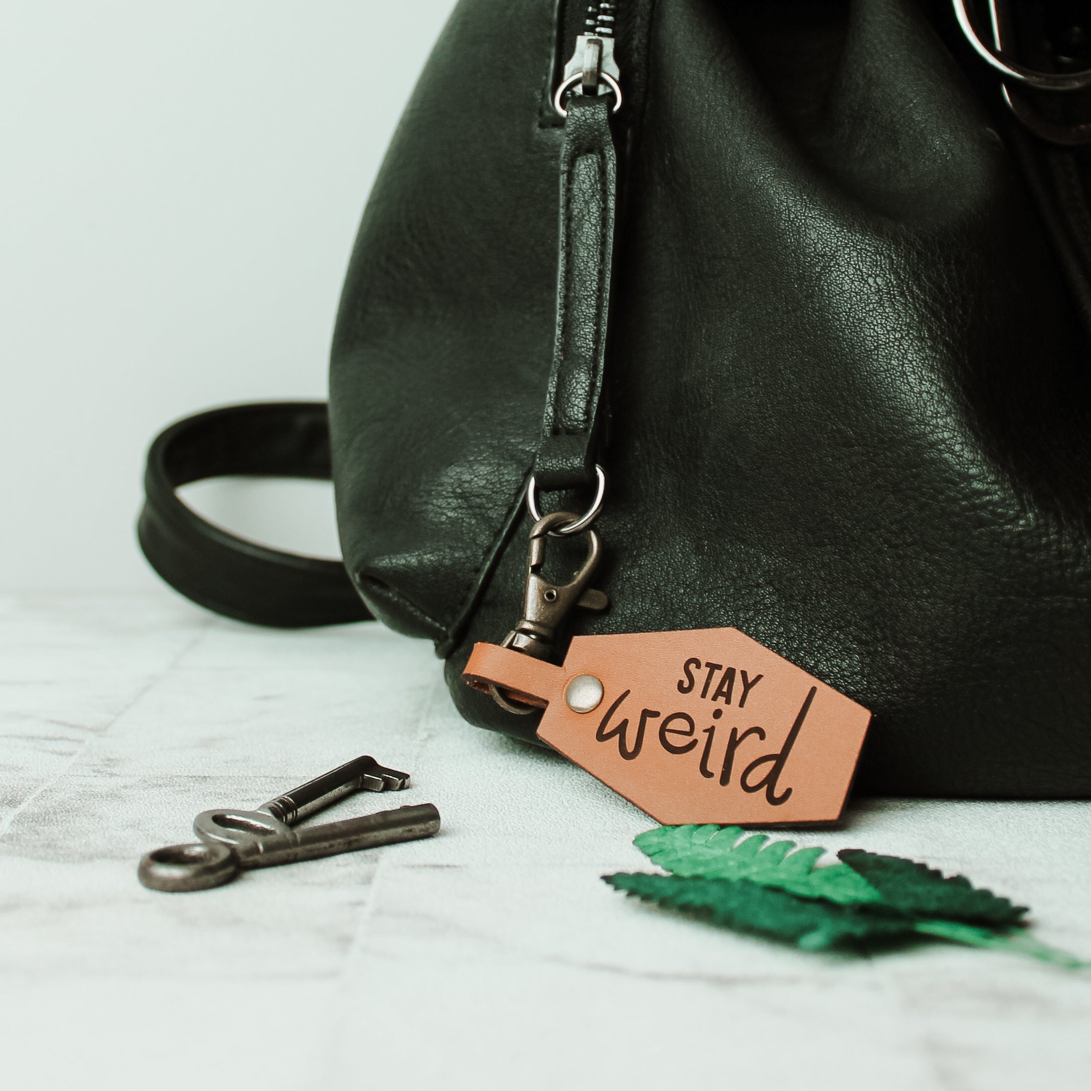 leather Keyring bag clasp engraved with the words stay weird with swivel clasp