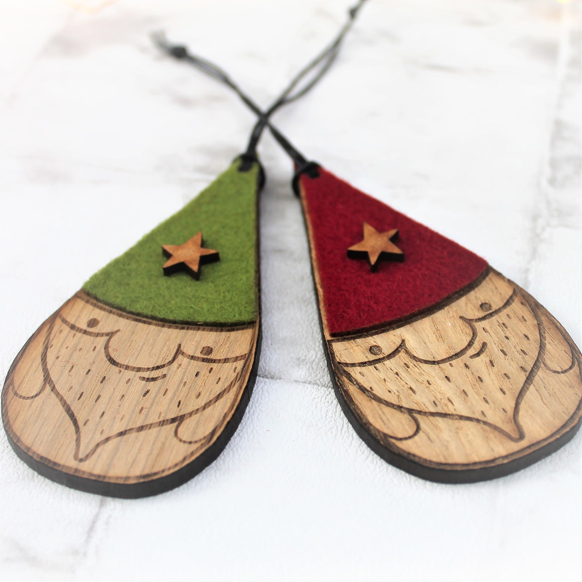 Set of 2 nisse / gnome baubles. With green and red hats with a star decoration. Made from wood and felt