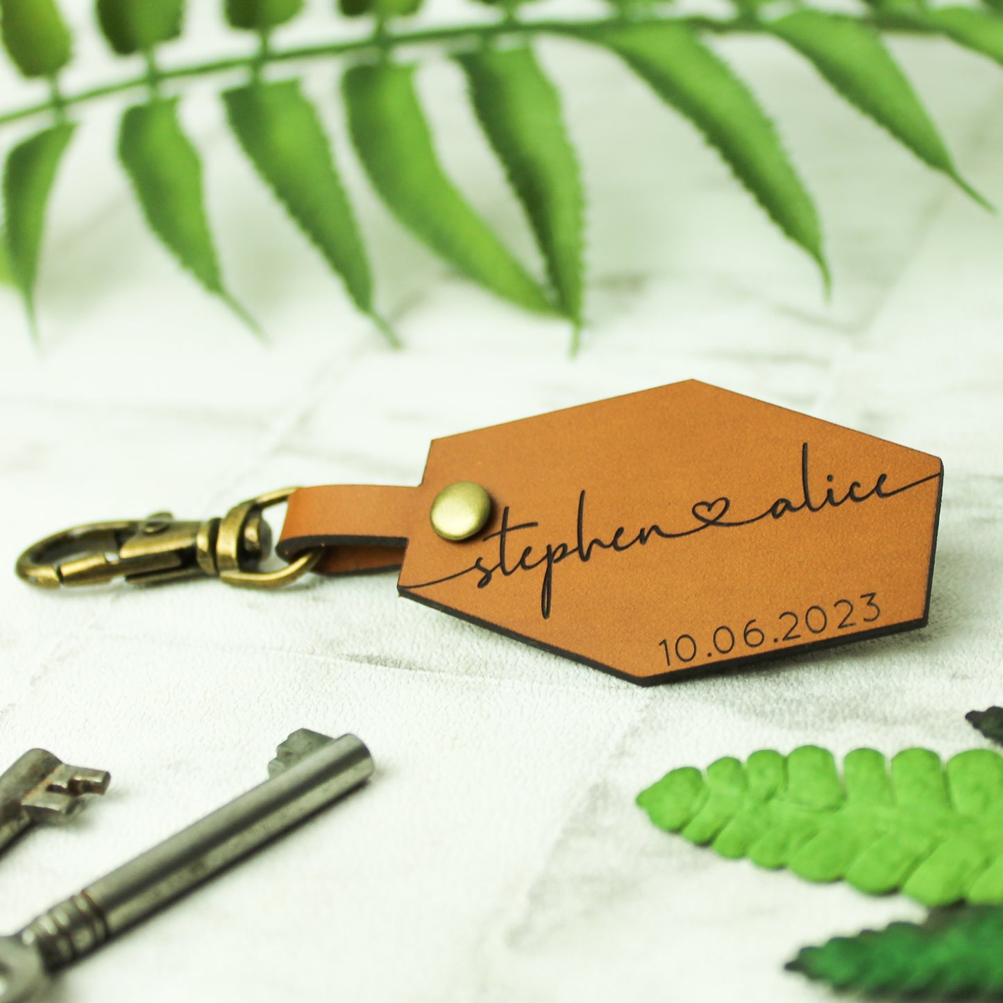 couple names and date engraved on a brown leather keyring perfect for anniversary